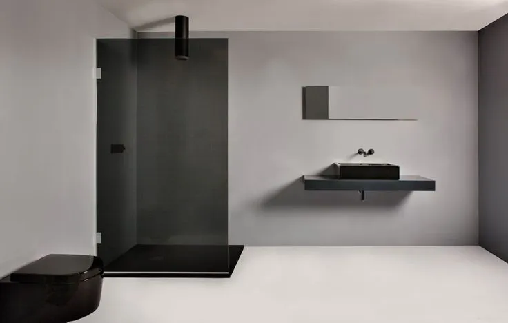 Een zwarte douchewand in combinatie met beton