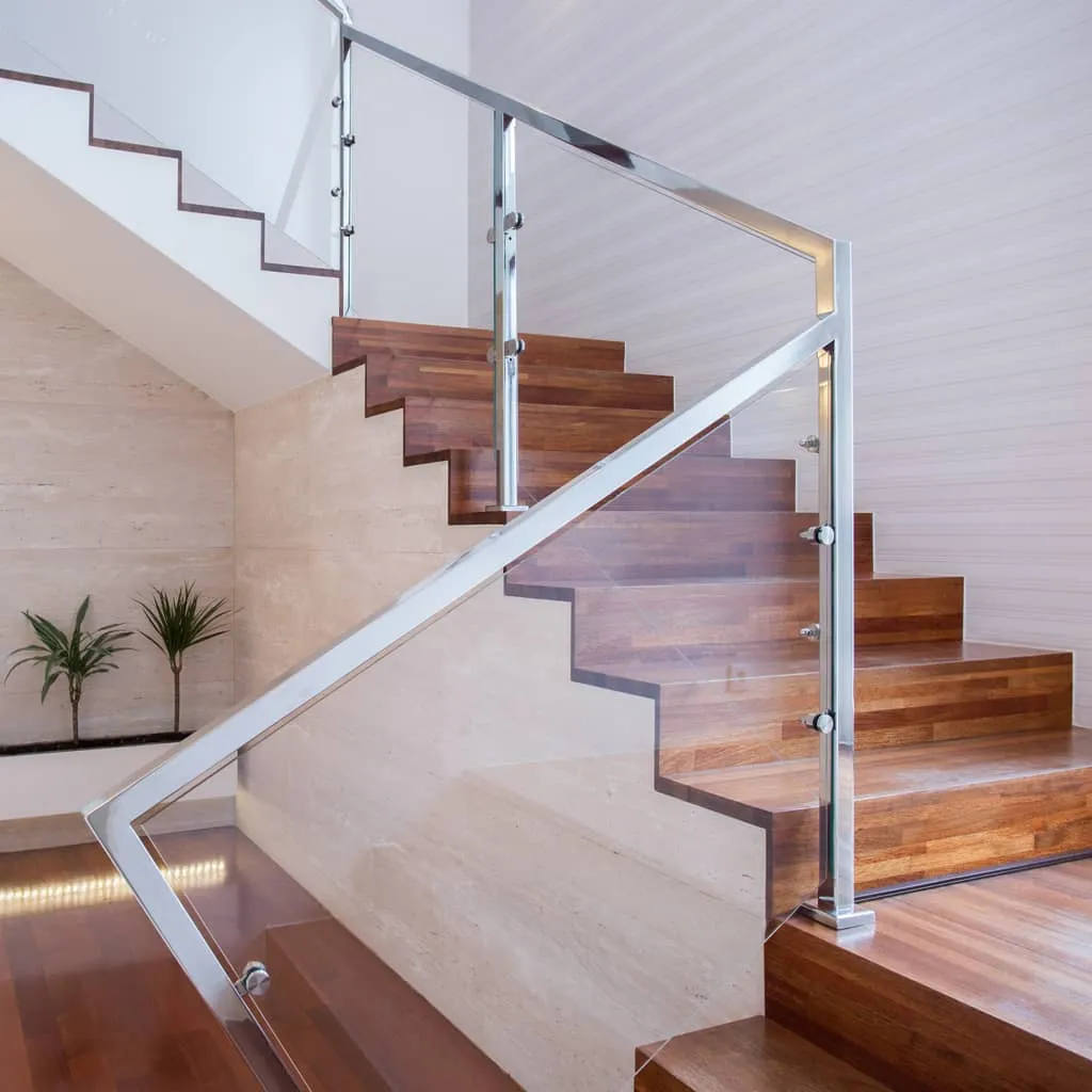 Houten trap met een glazen balustrade met rvs stijlen